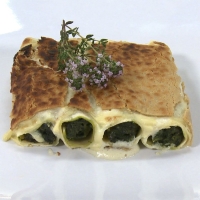 Spinach cannelloni with pine nuts and raisins au gratin with thyme béchamel sauce and vegan cheese